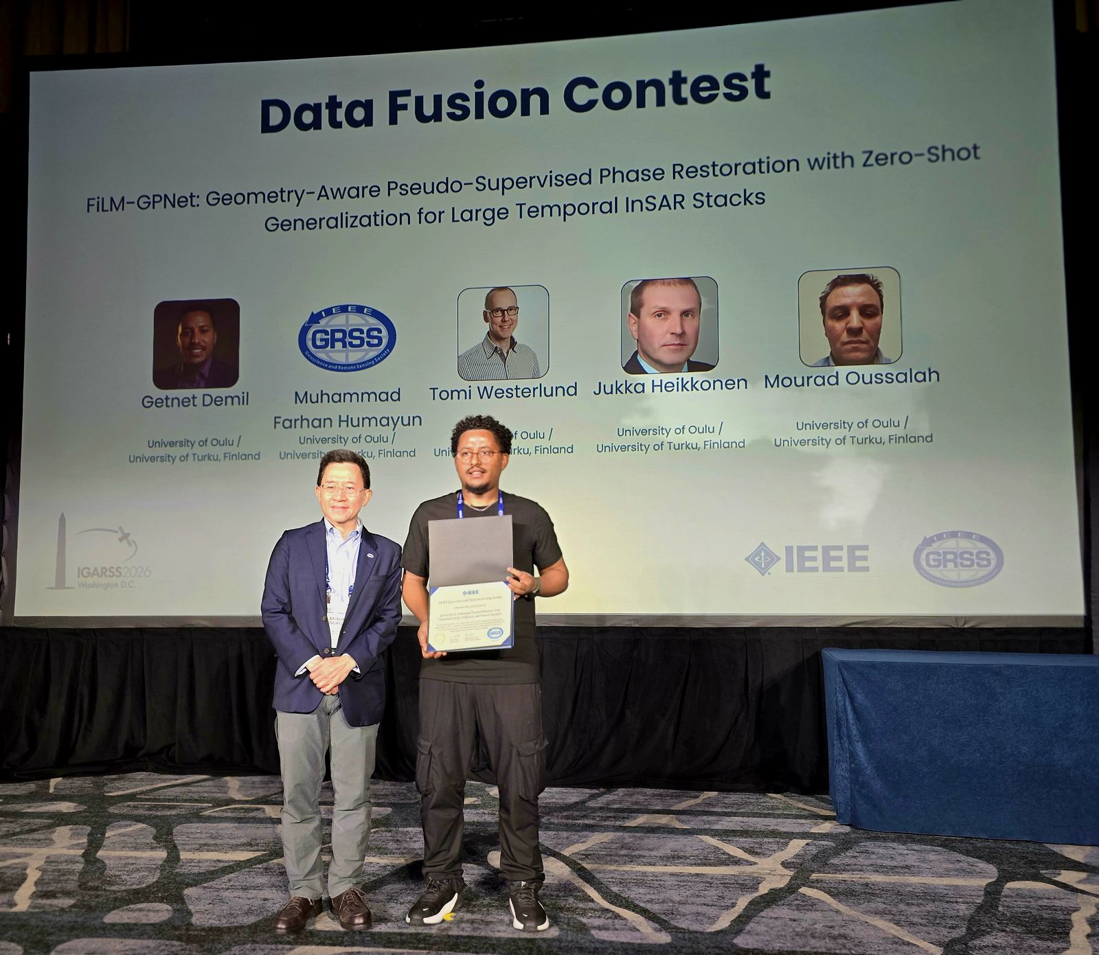 Receiving the Data Fusion Contest award on stage at IGARSS 2026