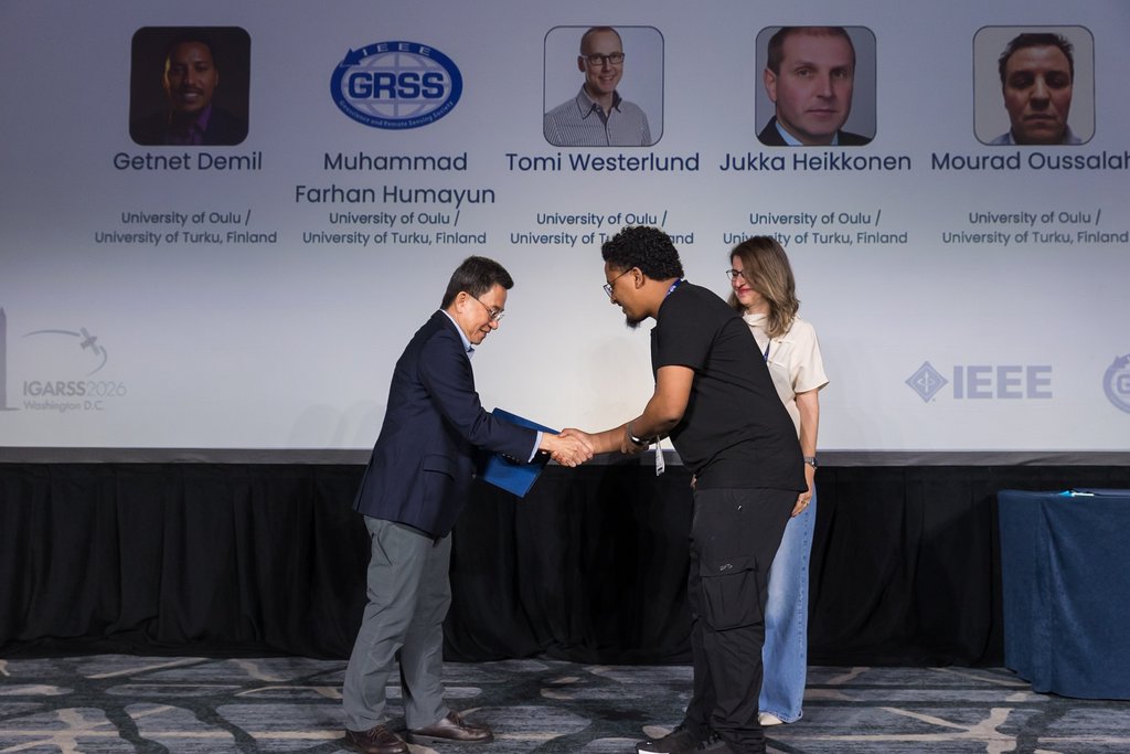 Receiving the certificate on stage at IGARSS 2026