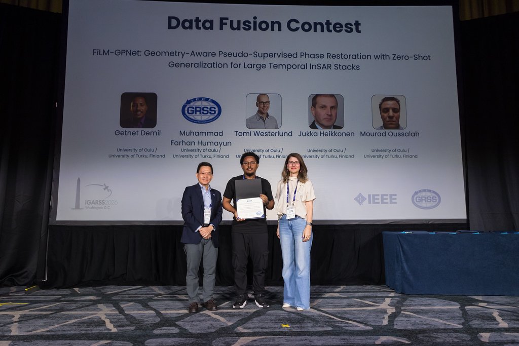 Team members posing with the certificate on stage
